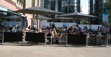 cafe, casual, crowd, day, England, eye level view, furniture, London, people, sitting, square, summer, sunny, The United Kingdom, umbrella