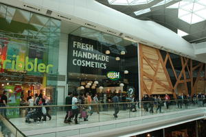 day, England, eye level view, group, indoor lighting, interior, London, mall, natural light, people, retail, shop, shopping, shopping centre, sign, The United Kingdom, walking
