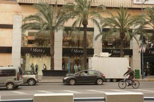 Alicante, car, cycling, day, eye level view, man, natural light, palm, retail, shop, Spain, street, sunny, Valenciana, vegetation