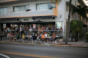 architecture, balcony, building, cafe, chair, crowd, dusk, eye level view, facade, Florida, Miami, object, people, sitting, standing, street, summer, table, The United States, vegetation, winter